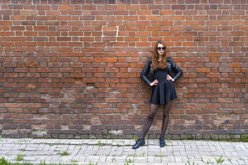 Girl with long hair near an old brick wall