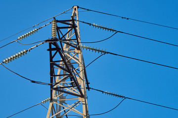 The support of the high-voltage transmission line against the blue sky