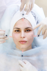 Top view of hands of several beauticians holding Syringes with injections