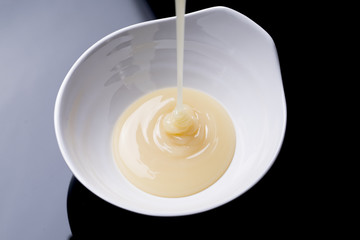 condensed milk on a black background, close up
