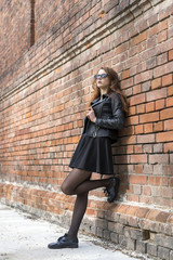 Girl with long hair near an old brick wall