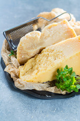 Traditional Italian hard cheese Parmesan and Grana Padano with grater and fresh basil