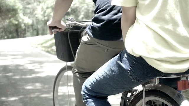 Close-up of adolescent ride a bicycle. Lower bodies pedaling.
