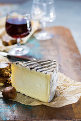 Sweet dessert liqueur wine in glass, hard french cheese Tomme de Montagne and dried figs with figs bread