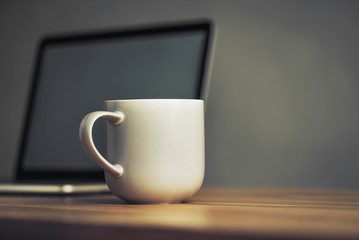 coffee cup and laptop in office table