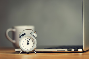 cup of coffee with clock and laptop