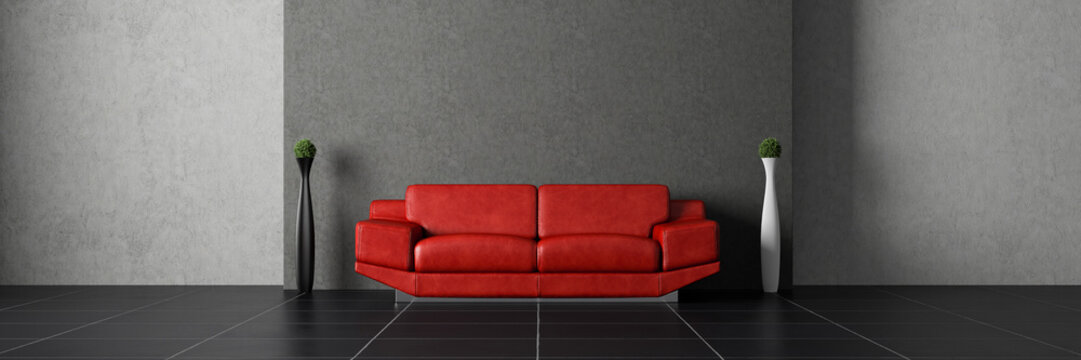 Red couch in front of concrete wall with 2 plants