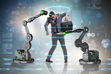 Businessman being manipulated by robotic arms