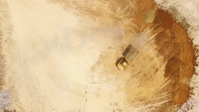 Aerial view of truck on muddy road on a construction site. Heavy industry from above. Industrial background from devastated landscape. 