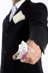 homme non reconnaissable en costume qui donne des billets en euros