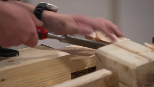 Hands of The Carpenter Work With a Chisel Process a Wooden Detail