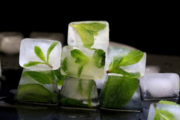 Ice with mint leaves on the black background