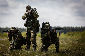 Special forces in a field with weapons