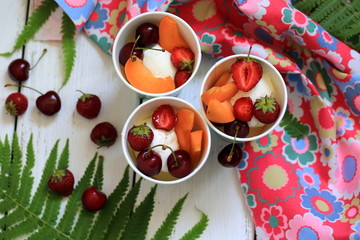 Vanilla ice cream with fruits in cups
