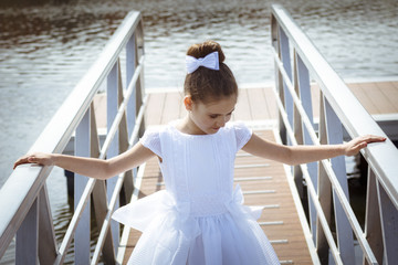 Niña rubia vestida de blanco en su primera comunión