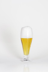 Glass of cold lager beer with foam on a white background isolated