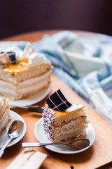 a beautiful delicious cake and the pieces in three white saucers on beige yellow cutting Board