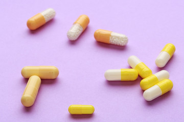Yellow pills on color background