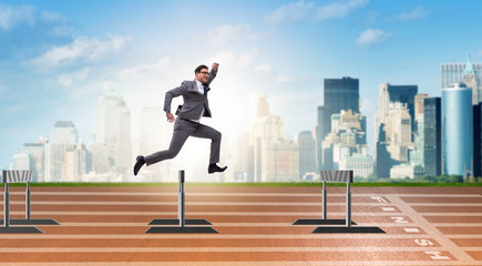 Fototapeta na wymiar Businessman jumping over barriers in business concept