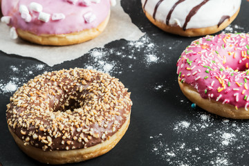 Donuts in a glaze assorted on a black background