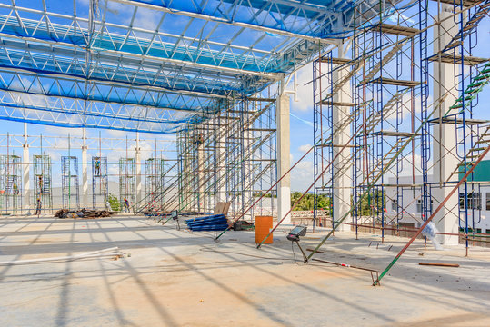 staircase and scaffolding on a construction site, Structure of steel roof frame for building construction covered with mesh