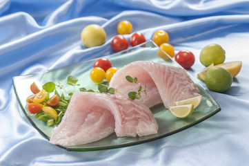raw white fish fillets with tomatoes and fresh oregano & Lemon slice 