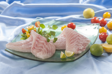 raw white fish fillets with tomatoes and fresh oregano & Lemon slice 