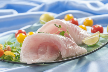 raw white fish fillets with tomatoes and fresh oregano & Lemon slice 