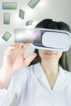 Young cheerful woman with vr headset. Woman in VR headset looking up and trying to touch objects in virtual reality.  Businessman toched a social network button on touch screen. 