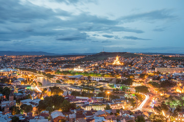 Naklejka premium Capital of Georgia - Tbilisi at night against the dark blue sky.