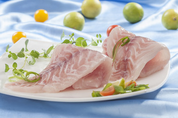 raw white fish fillets with tomatoes and fresh oregano & Lemon slice 