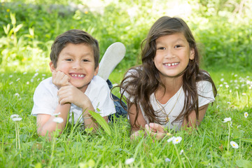 2 children brother and sister lying in the grass