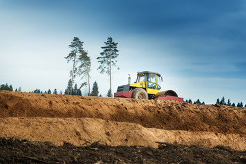 Large view on the compactor working on the new road construction site