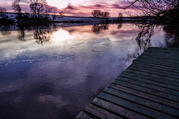 Wooden pier stretching into the lake at dawn