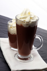 Hot chocolate cocoa with whipped cream on vintage wooden backgro