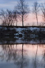 Fototapeta premium trees and the shores reflected in the water of the river at sunset