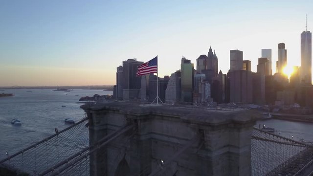 dusk aerial shot circling Brooklyn Bridge clockwise with downtown Manhattan in background