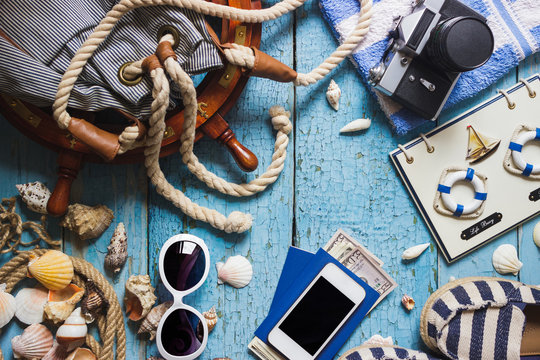 Striped slippers, phone and maritime decorations on the wooden background