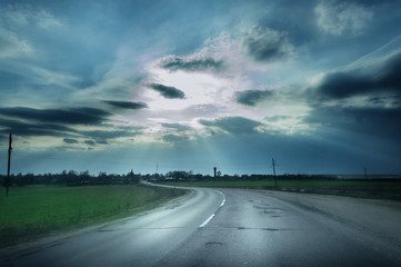 The road through the meadow and the stormy skies