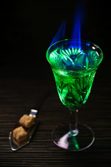 absinthe in glass and spoon with  brown sugar cubes