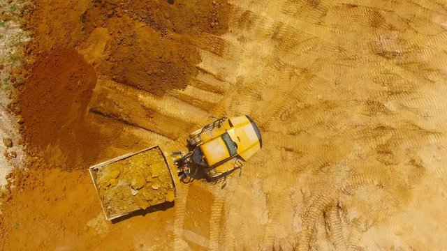 Aerial view of truck on muddy road on a construction site. Heavy industry from above. Industrial background from devastated landscape. 