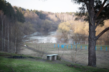 Bench on the bank of the river in summer day