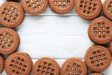 Chocolate cookies with cream on white wooden table