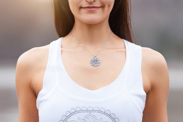 Portrait of young attractive woman practicing yoga on nature shore in the lake