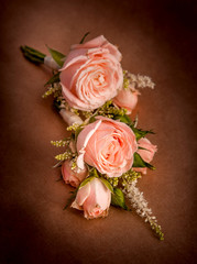 Wedding boutonniere of roses on a background of brown kraft paper