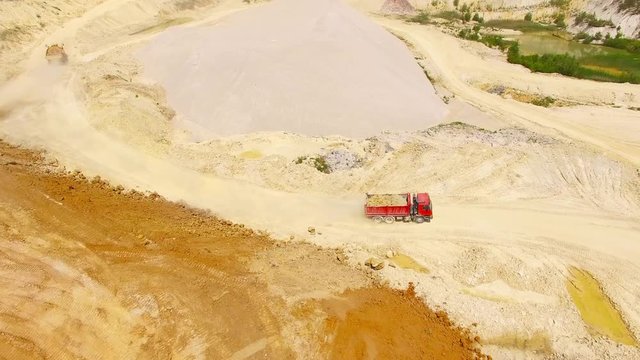 Aerial view of truck on muddy road on a construction site. Heavy industry from above. Industrial background from devastated landscape. 