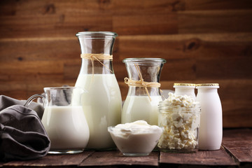 milk products - tasty healthy dairy products on a table on: sour cream in a white bowl, cottage cheese bowl, cream in a a bank and milk jar, glass bottle and in a glass