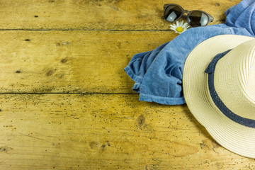Straw hat, sunglasses and other accessories for summer on a wooden table