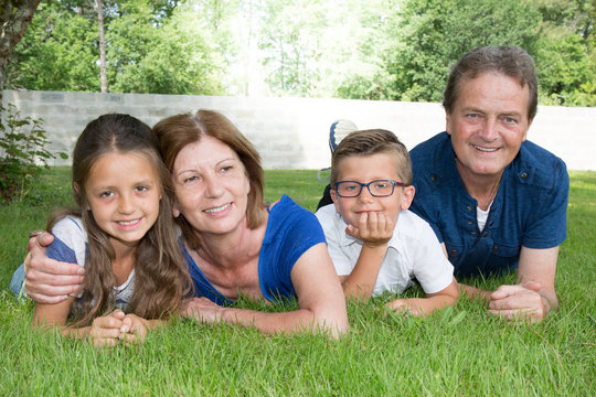 Grandparents and grandchildren lying in the grass of the garden