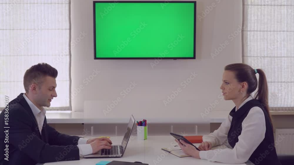 Aufkleber business partners discussing project. adult workers sitting in office on wall monitor with green scr